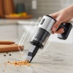 Compact cordless vacuum cleaner in hand cleaning kitchen counter crumbs quickly
