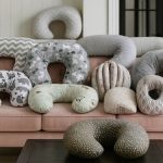 Close-up of ergonomic baby nursing pillow on a bed