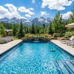 Crystal clear backyard swimming pool surrounded by scenic Colorado mountain views.